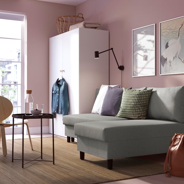 ÄLVDALEN convertible sofa in modern living room with storage, decorative pillows, coffee table, and artwork.