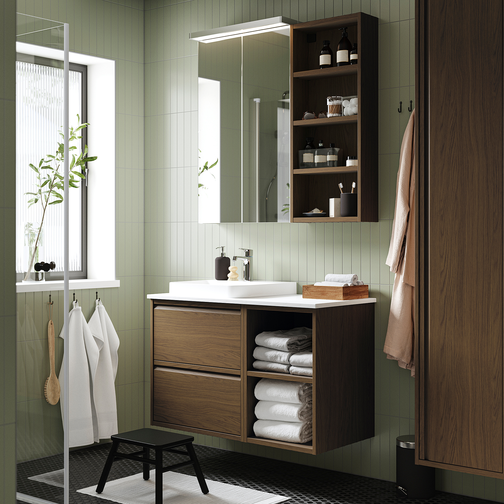 Green bathroom with dark wood ÄNGSJÖN vanity, white sink, mirror, & storage.