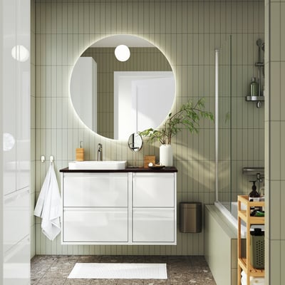 Modern bathroom with ÄNGSJÖN vanity, mirror, shower, towel, plant, and storage rack.