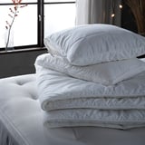 Stacked white pillows on bed, clean design.