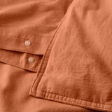Earthy-toned duvet with press-stud closure, showing soft, breathable cotton.