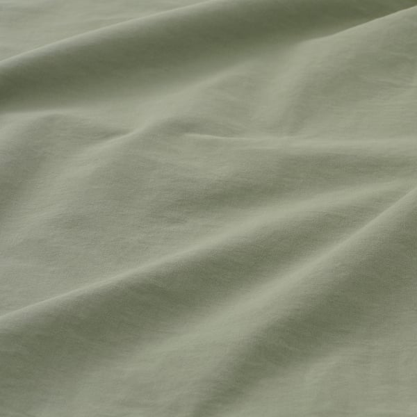 Soft, green pillowcase in close-up, showcasing smooth, high-quality cotton fabric with light folds.