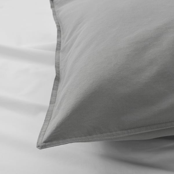 Close-up of soft, textured grey pillowcase, folded neatly, showing smooth cotton fabric.