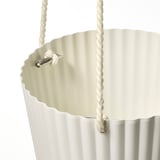 Close-up of stylish hanging planter with white, braided rope handles.