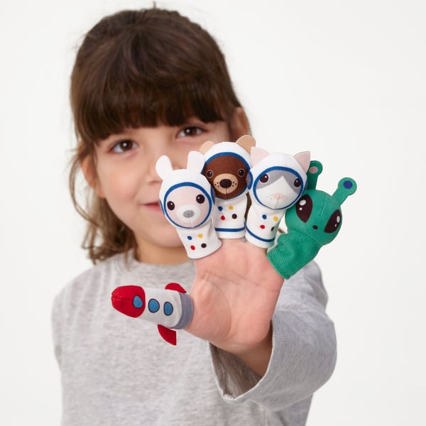 Girl holds colorful finger puppets: astronauts, rocket. Ideal for storytelling.