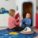 Children playing with finger puppets in front of a colorful playhouse.