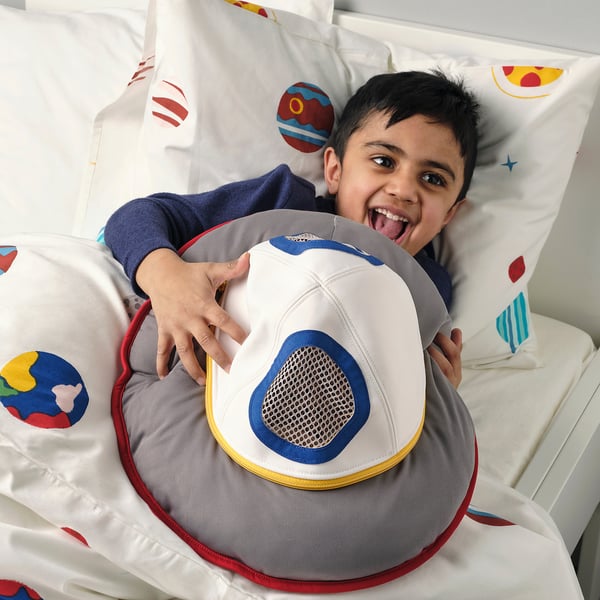 Boy in spaceship tent with alien toy.