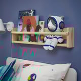 Blue kids room with astronaut cat toy on wooden shelf near bed.