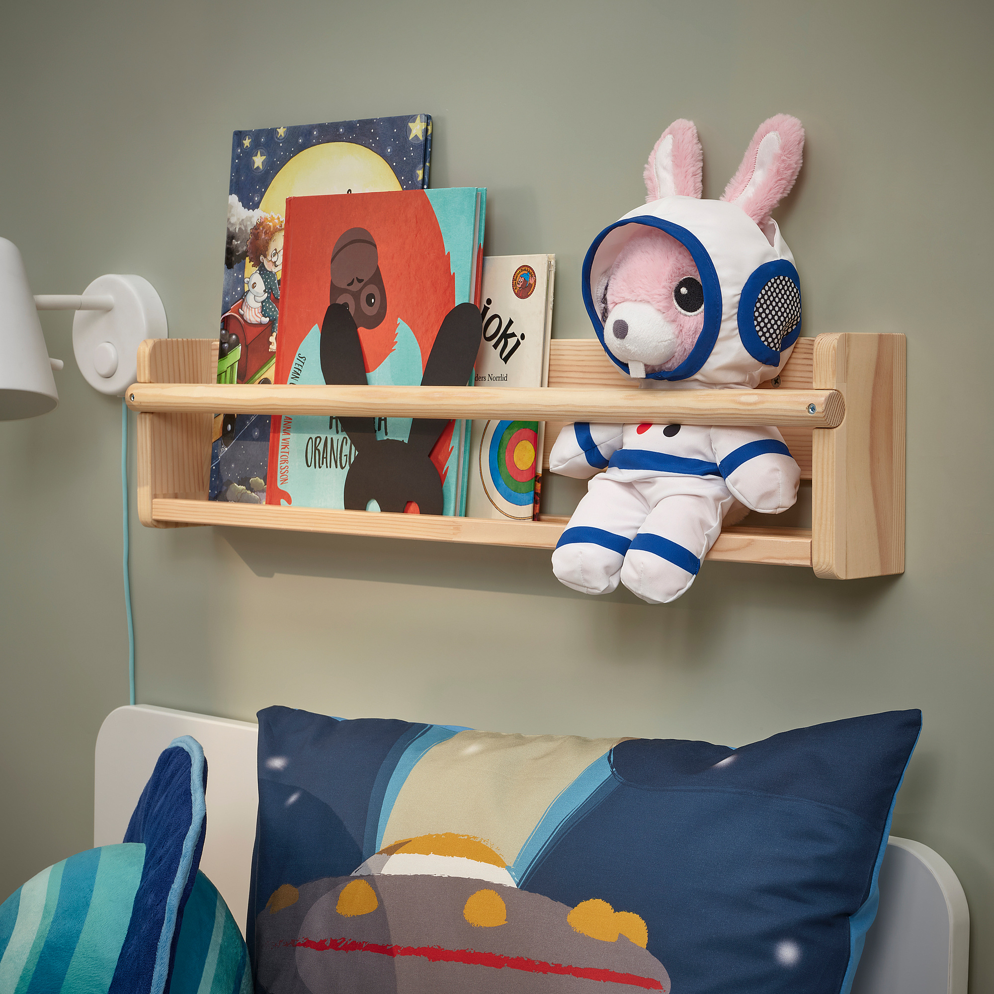 Kids room with book shelf, astronaut toy, blue pillow bed.