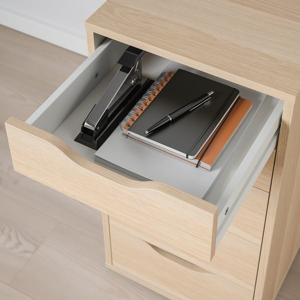 Open wooden drawer with notebook, pen, and stapler inside. Finished back for versatile placement.