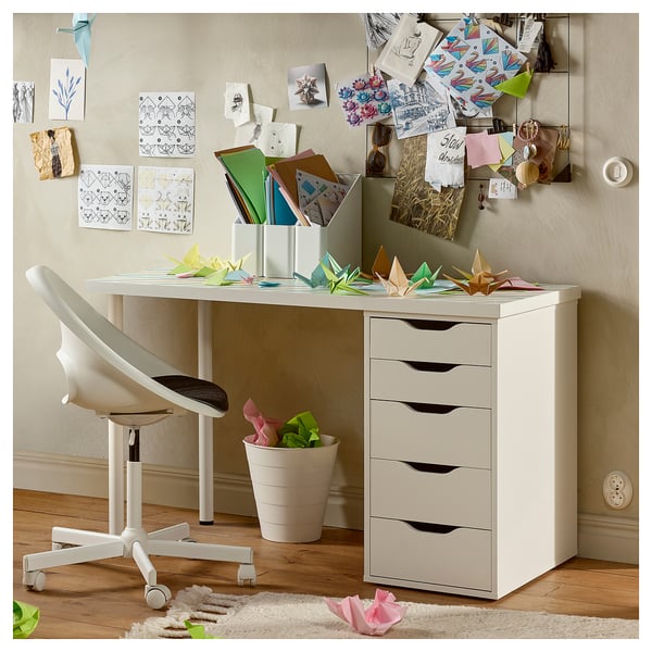 A white ALEX desk with drawers, chair, and colorful paper origami on top and walls.