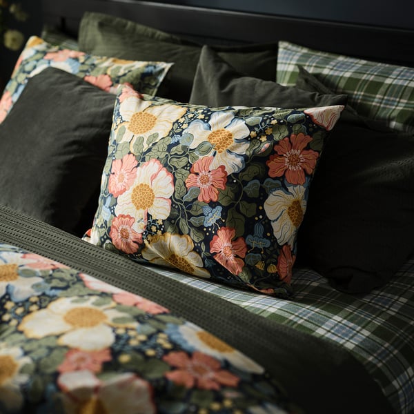 Floral printed pillow on dark bedding, soft and detailed, part of ARENBOK set.