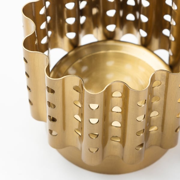 Gold-colored metal tealight holder with wavy, perforated design.