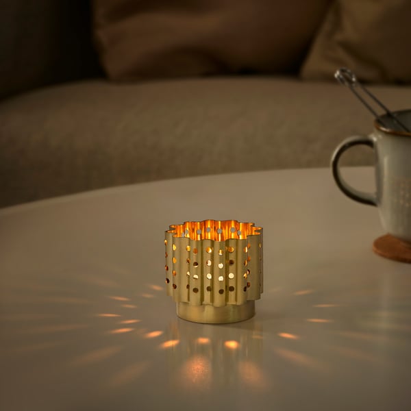 AROMATISK brass-colored tealight holder, wavy design, small size, stainless steel, emits soft light, table decoration.