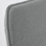 Close-up of modern, upholstered chair in gray fabric, showcasing smooth, clean lines and quality stitching.