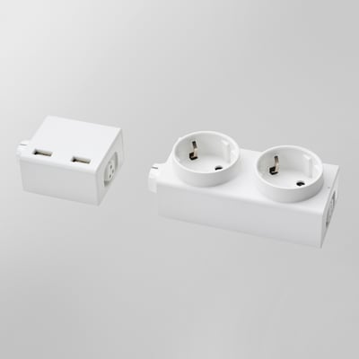 Two white ÅSKVÄDER power modules are displayed, one with dual usb ports and the other with two schuko sockets.