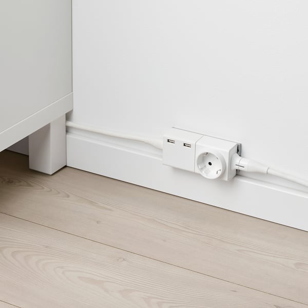 White electrical outlet with usb ports on a wooden floor.