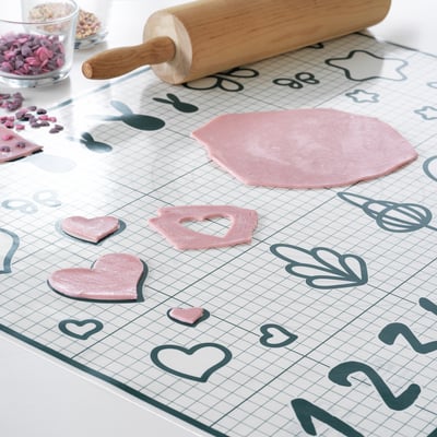 BAKTRADITION silicone mat shows pink dough hearts, wooden roller, fun designs.