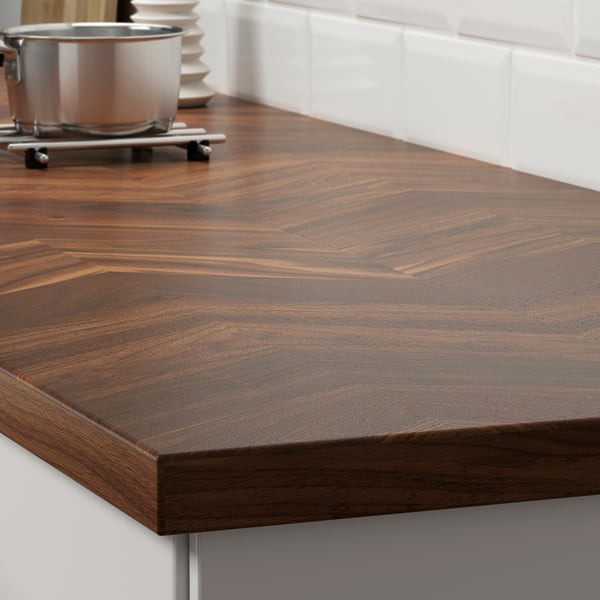 Dark brown wooden countertop with visible grain patterns, suggesting natural durability and aesthetic appeal, supported by metal brackets.