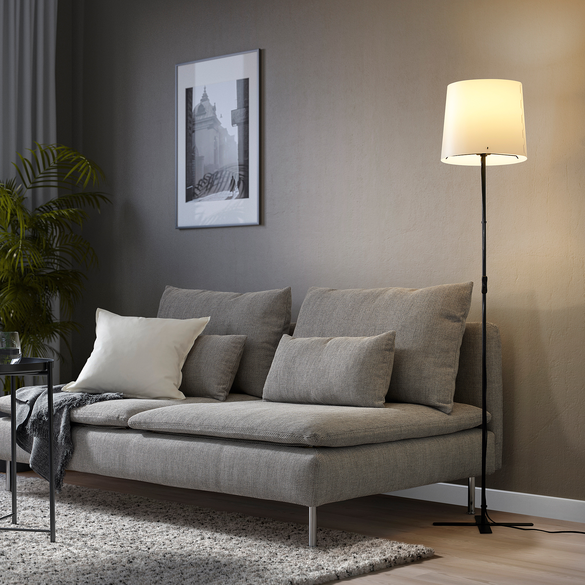 BARLAST lamp beside gray sofa, minimalist living room with plant.