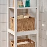 White shelving unit with woven baskets; great for bathroom storage, durable handwoven plastic rattan.