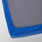 A close-up of a blue and gray bed mattress cover, showcasing its soft texture and secure elastic edge.