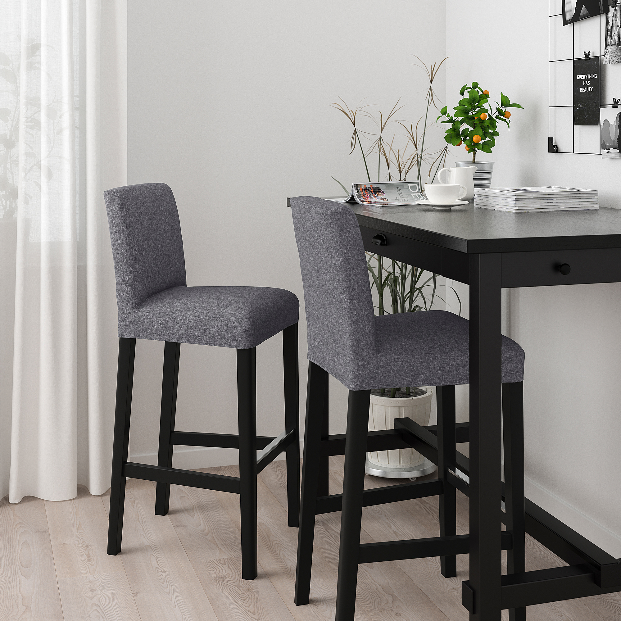 Two gray bar stools with black legs and counter in minimalist setting.