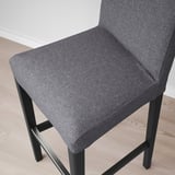 Modern grey fabric bar stool with sleek black metal legs; designed for comfort and style.