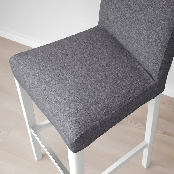 Close-up of a modern, cushioned grey stool with white metal legs. Soft, inviting upholstery.