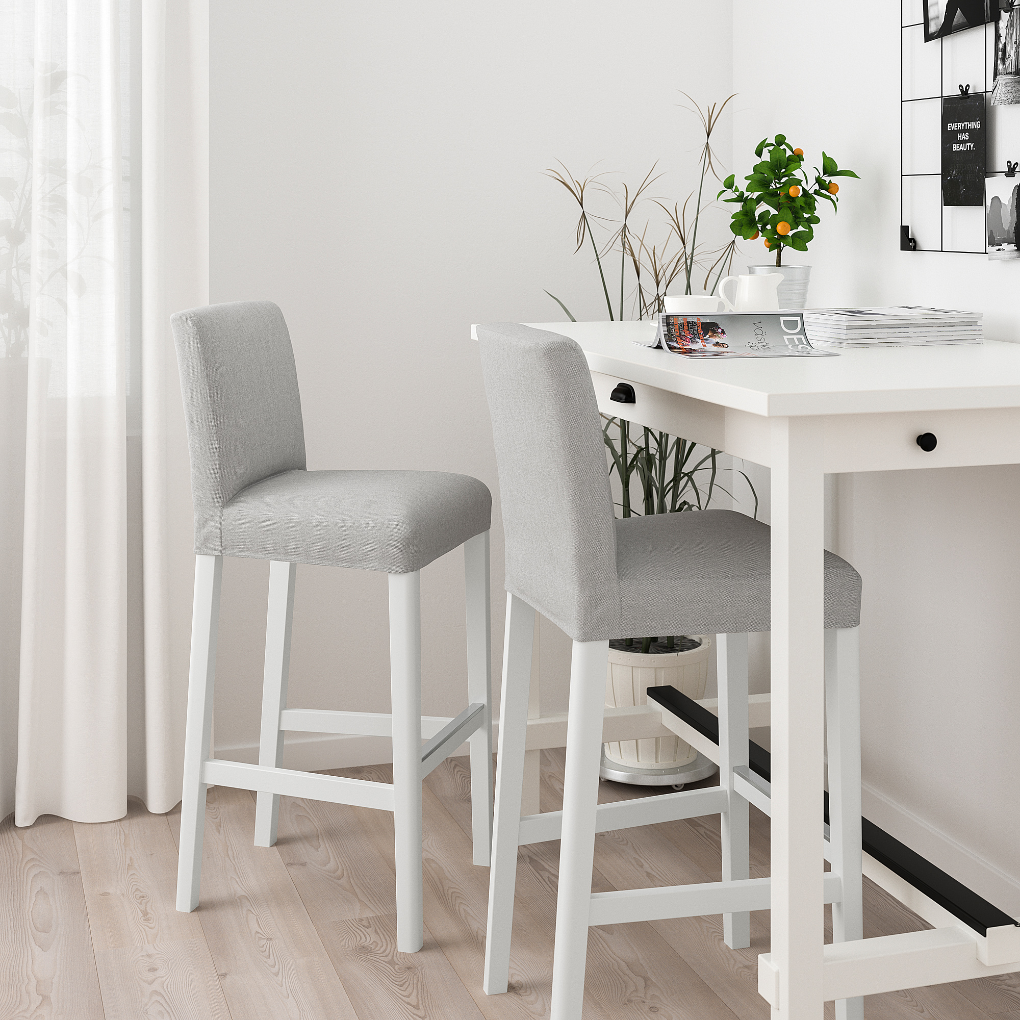 Two grey BERGMUND bar stools at white table, white room, minimalist design.