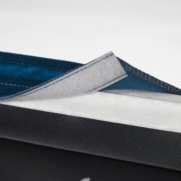 Pile of folded fabric chair covers in blue, grey, and black. Easy to clean and removable for washing.