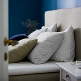 Pillows stacked on bed, featuring white & striped gray BERGPALM cases, soft cotton, classic striped design.