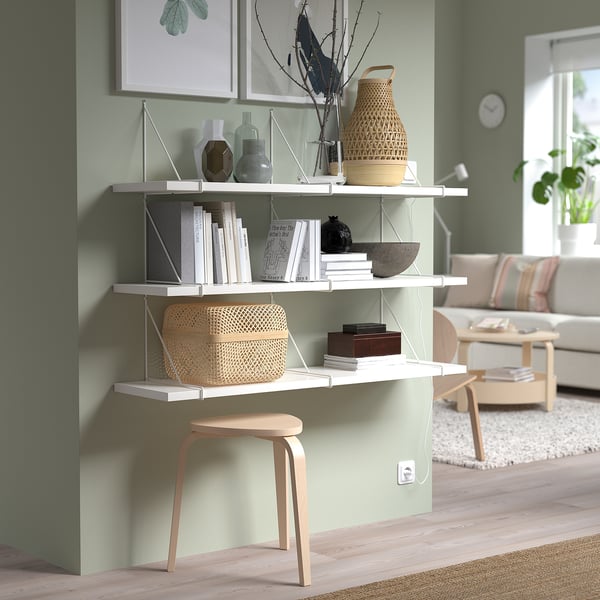 Modern living room with BERGSHULT shelf & decor. Green wall background.