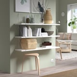 Modern living room with BERGSHULT shelf & decor. Green wall background.