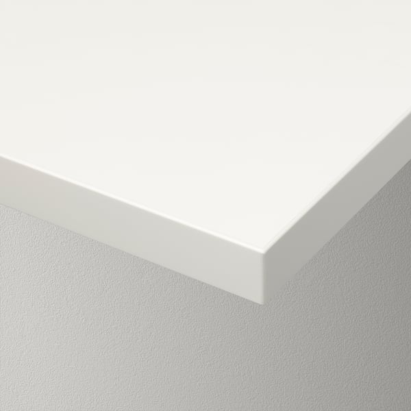 White wall shelf corner with smooth and beveled edge, mounted on a textured wall.