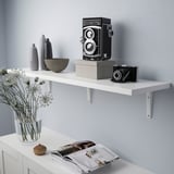 White wall shelf displaying an old camera and vases.
