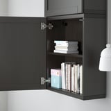 Black cabinet with open door revealing adjustable shelves filled with books.