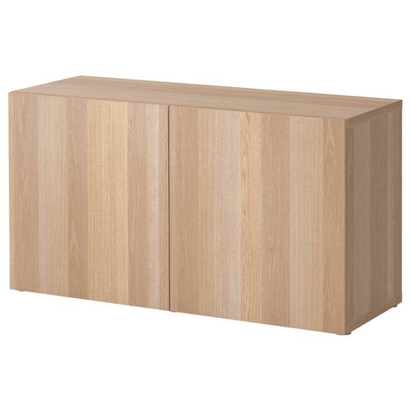 An ikea BESTÅ storage unit in light wood color, featuring two closed cabinet doors.