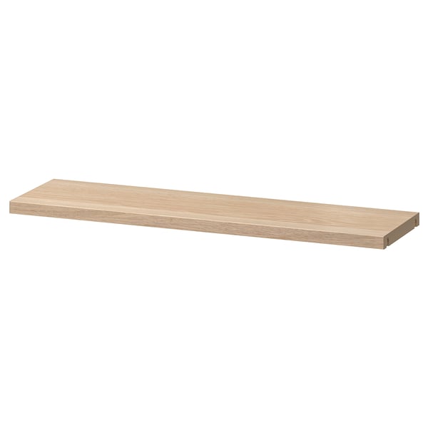 An ikea BESTÅ adjustable wooden shelf. It is rectangular, light brown, and made of particleboard with plastic edging.