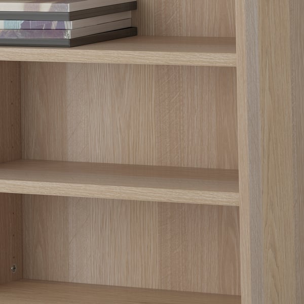Wooden shelves, adjustable, holding books. Part of BESTÅ storage system.