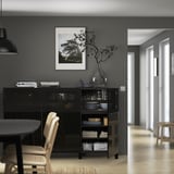 Modern dining area with sideboard, dishes, decor, art, and shelves. Light wooden floor.