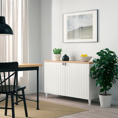 BESTÅ sideboard with soft-closing doors, table, chairs, and decor in minimalist room.