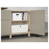 Open cabinet with books and boxes on shelf. Drawers below, adjustable hinges visible.