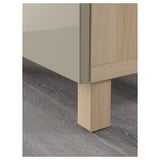 A close-up of a wooden cabinets leg, smoothly finished and firmly attached to a modern sideboard.