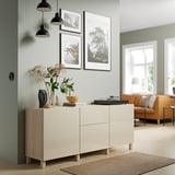 BESTÅ sideboard with drawers and shelves, modern design, surrounded by art, plants, record player, green wall.
