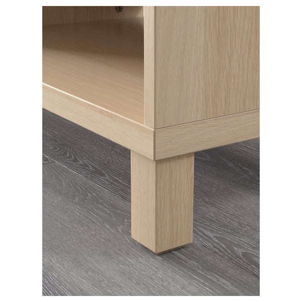 Light wood tv stand close-up, showing sturdy leg and adjustable shelf.