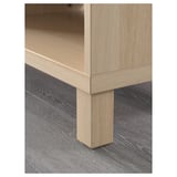 Light wood tv stand close-up, showing sturdy leg and adjustable shelf.