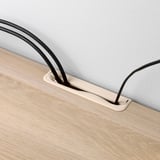 A modern tv stand with built-in cable management, featuring sleek black curves and a beige drawer, designed to keep cords organized and hidden.