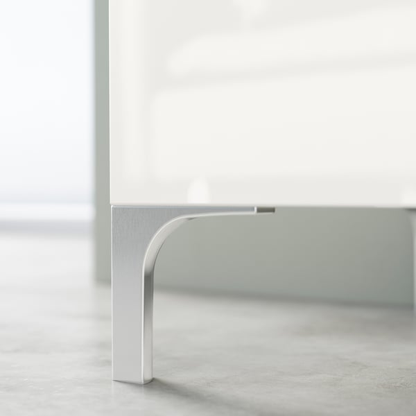 Silver metal leg supporting a white tv cabinet, showcasing modern minimalist design.