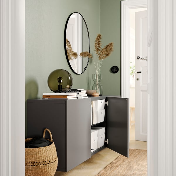 Modern entryway with green walls, BESTÅ unit, mirror, and basket.